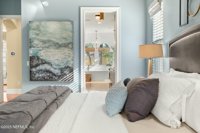 bedroom featuring an inviting chandelier and ensuite bath