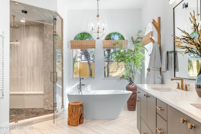 bathroom featuring vanity, plus walk in shower, and a notable chandelier