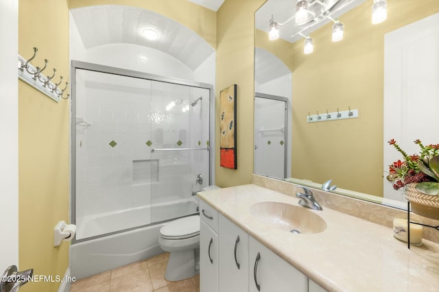 full bathroom featuring tile patterned flooring, vanity, toilet, and bath / shower combo with glass door