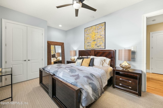 bedroom with ceiling fan, a closet, and light colored carpet