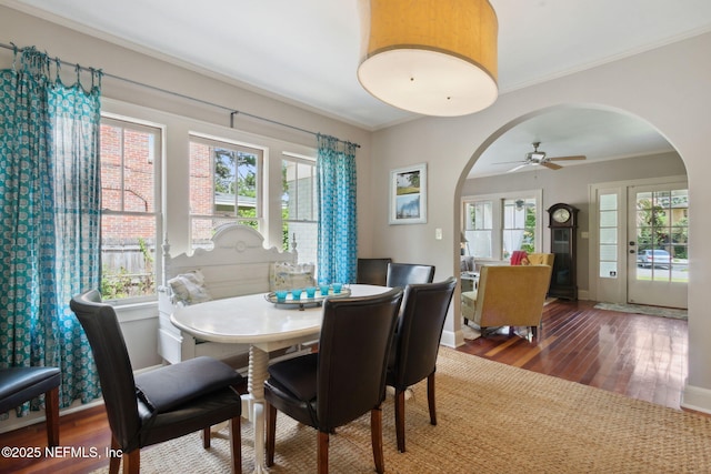 dining space with ornamental molding, ceiling fan, and dark hardwood / wood-style floors