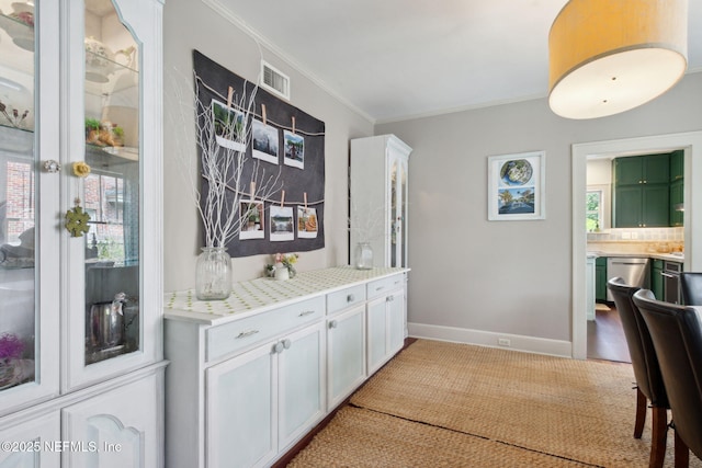 bar with dishwasher, white cabinets, tasteful backsplash, and crown molding