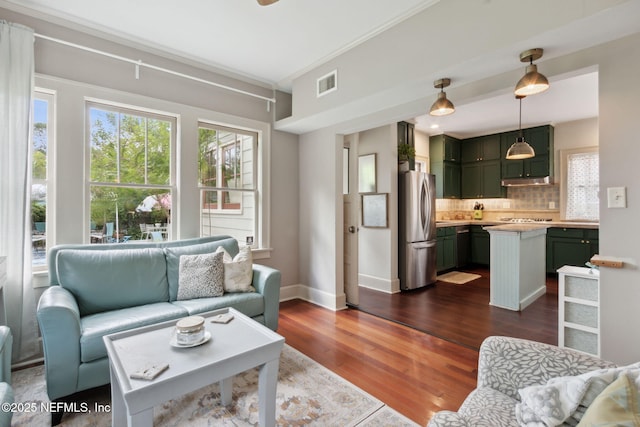 living room featuring dark hardwood / wood-style flooring and crown molding