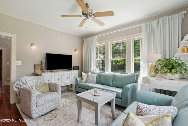 living room featuring ornamental molding, light wood-type flooring, and ceiling fan