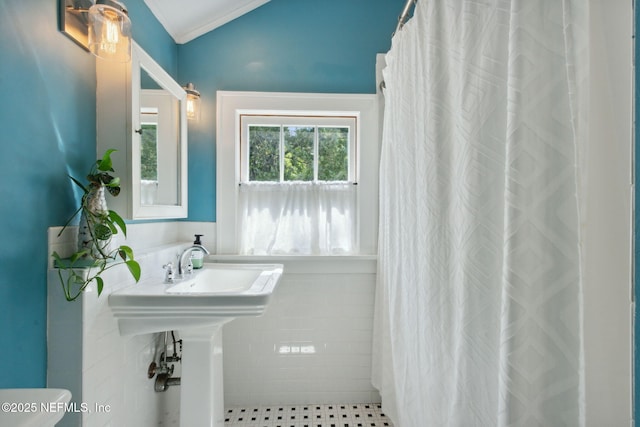 bathroom featuring lofted ceiling, crown molding, and walk in shower