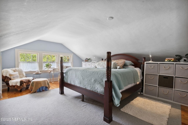 bedroom featuring hardwood / wood-style flooring, a textured ceiling, and vaulted ceiling