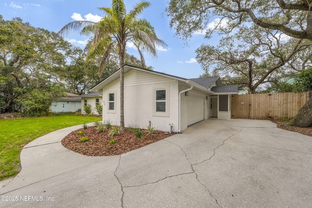 view of side of home featuring a garage and a lawn