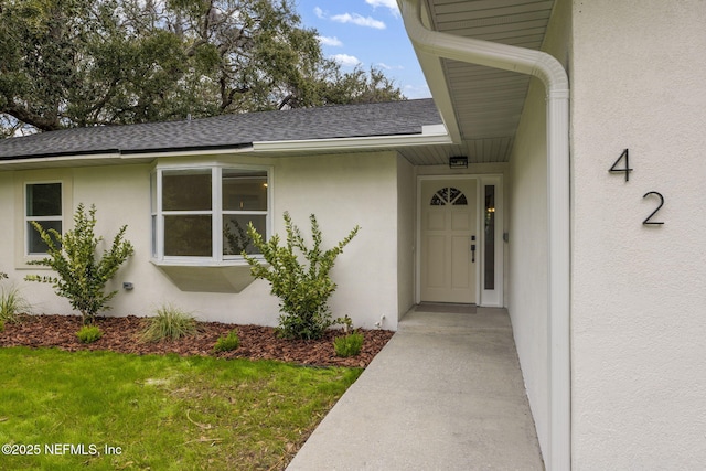 doorway to property featuring a lawn