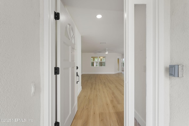 corridor with light hardwood / wood-style floors