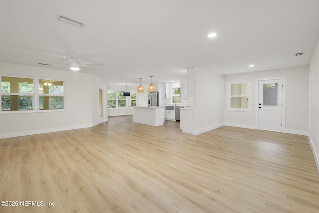 unfurnished living room with ceiling fan and light hardwood / wood-style flooring