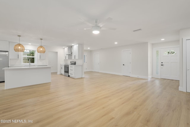 unfurnished living room with ceiling fan and light hardwood / wood-style floors