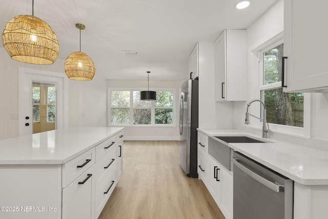 kitchen featuring appliances with stainless steel finishes, pendant lighting, and white cabinetry