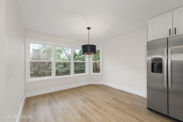 unfurnished dining area featuring light wood-type flooring