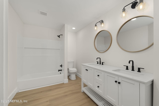 full bathroom featuring hardwood / wood-style flooring, toilet, vanity, and shower / bathtub combination