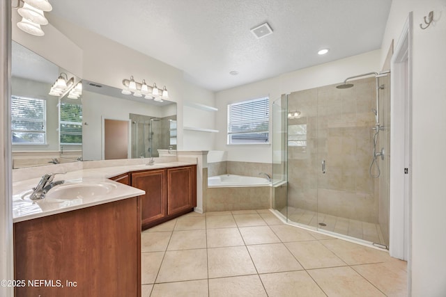 bathroom with a textured ceiling, a wealth of natural light, tile patterned floors, and separate shower and tub