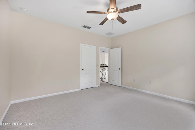 spare room with light colored carpet and ceiling fan