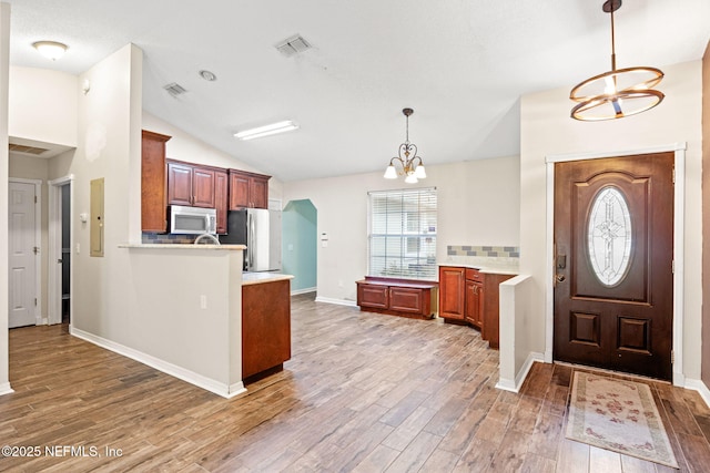 foyer with a chandelier, lofted ceiling, and hardwood / wood-style flooring