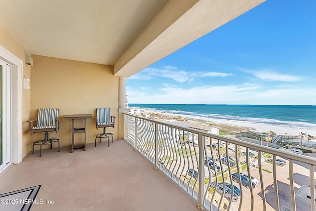 balcony featuring a water view and a beach view