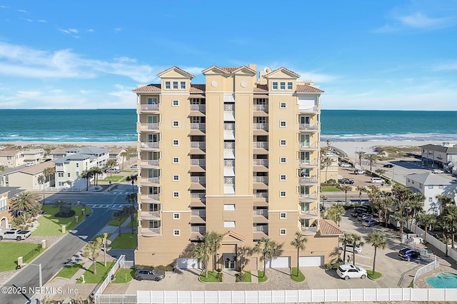 view of building exterior featuring a beach view and a water view