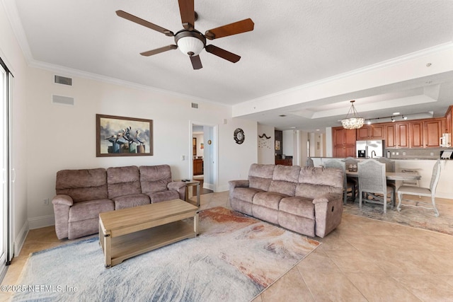 living room with ceiling fan with notable chandelier, a textured ceiling, light tile patterned floors, and crown molding