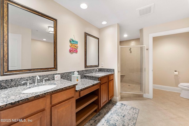 bathroom with toilet, vanity, tile patterned floors, and a shower with door