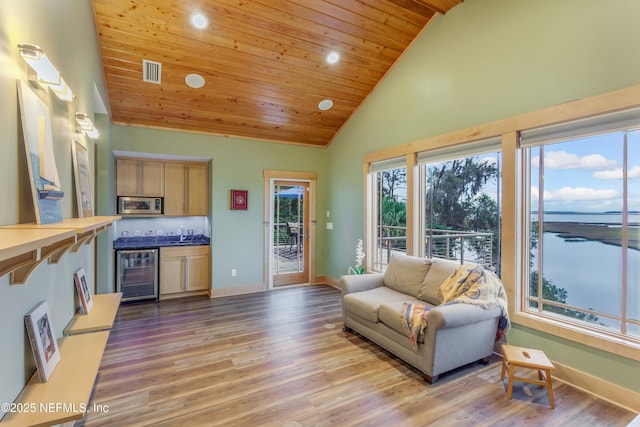 living room featuring a water view, beverage cooler, high vaulted ceiling, and light hardwood / wood-style flooring