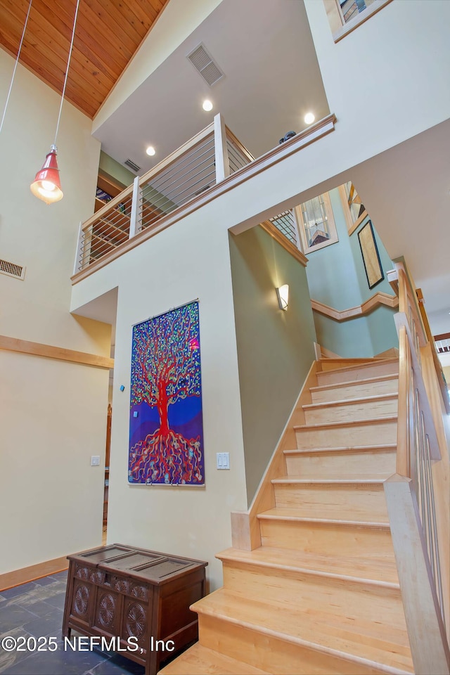 staircase with a high ceiling and wood ceiling