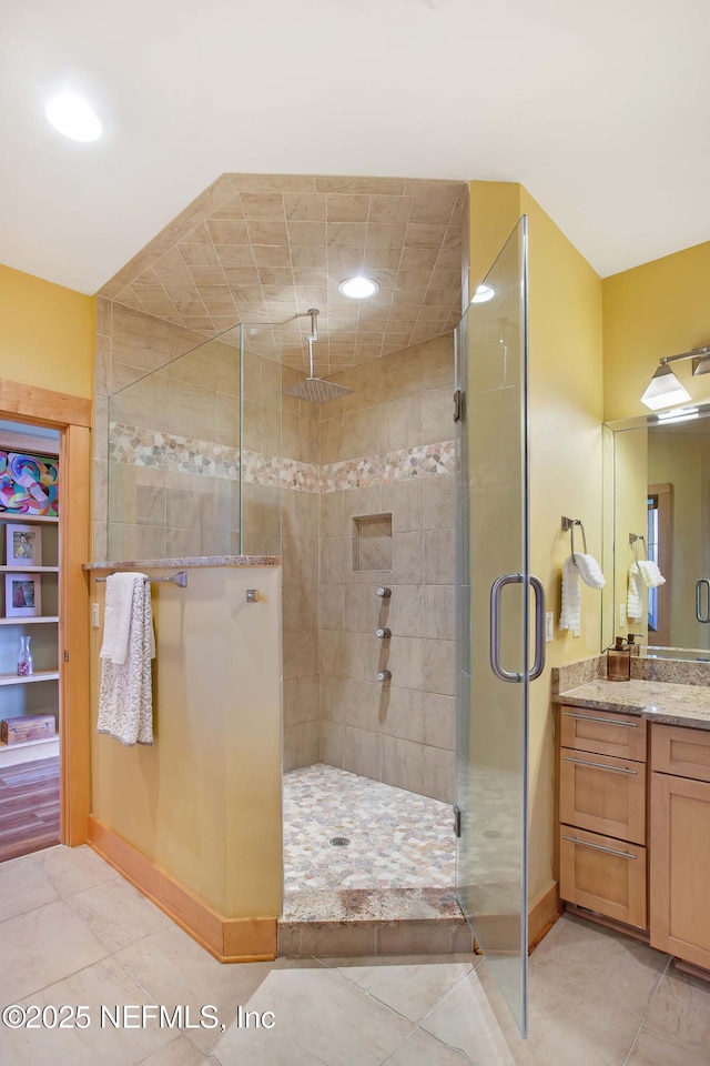 bathroom featuring vanity, tile patterned floors, and a shower with door