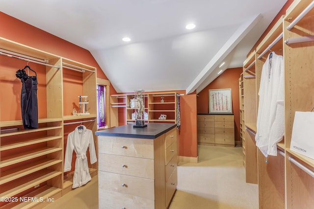 spacious closet featuring lofted ceiling and light colored carpet