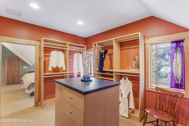 spacious closet with lofted ceiling and light carpet