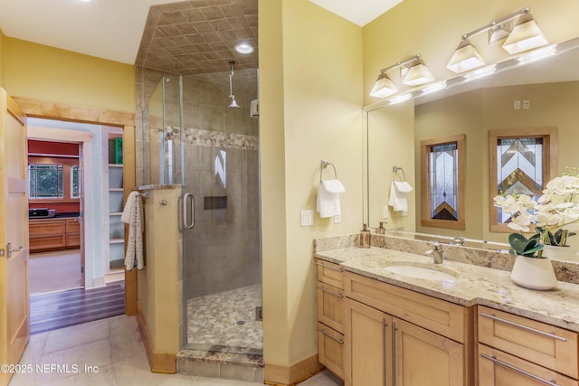 bathroom featuring tile patterned flooring, vanity, and walk in shower