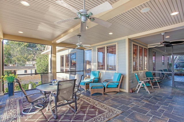 sunroom featuring ceiling fan and wood ceiling