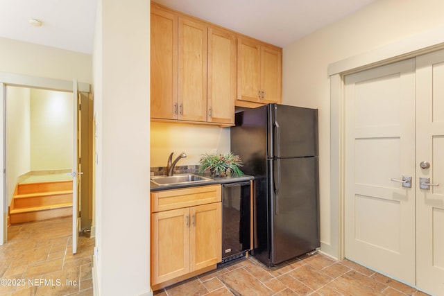 kitchen with light brown cabinetry, sink, and black appliances