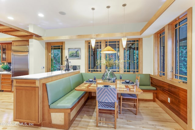 dining space featuring breakfast area, light hardwood / wood-style floors, and wood walls