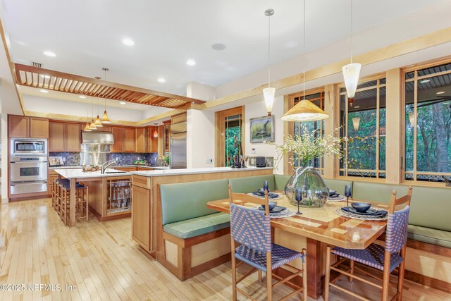 dining room with sink, wine cooler, and light hardwood / wood-style floors