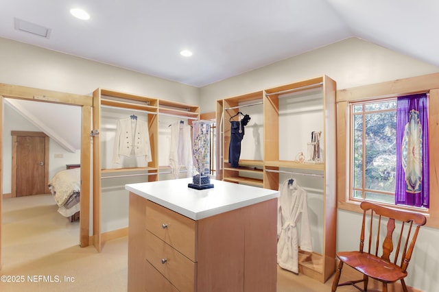 walk in closet featuring lofted ceiling and light colored carpet