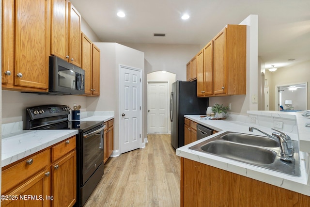 kitchen featuring kitchen peninsula, appliances with stainless steel finishes, light hardwood / wood-style floors, and sink