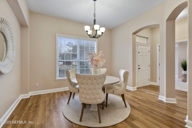 dining area featuring hardwood / wood-style floors and a notable chandelier