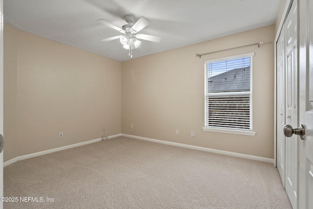 empty room with ceiling fan and light carpet