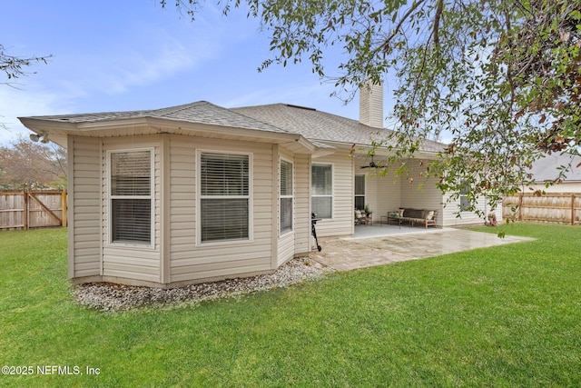 rear view of house with a patio area, ceiling fan, and a yard