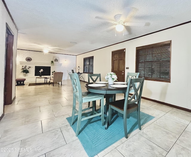 tiled dining space featuring ceiling fan, brick wall, crown molding, and a textured ceiling