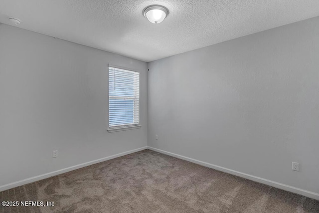 carpeted empty room featuring a textured ceiling