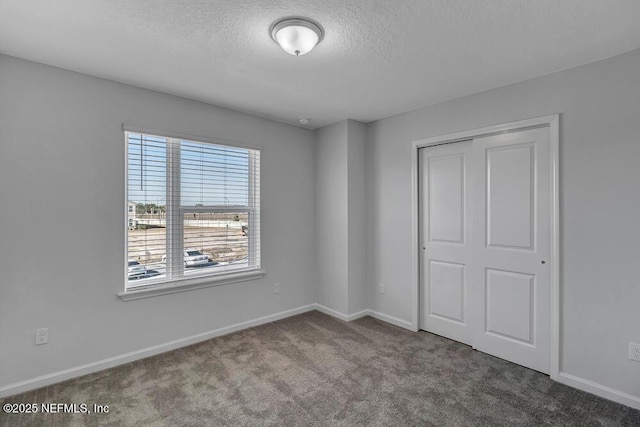 unfurnished bedroom featuring carpet floors, a closet, and a textured ceiling