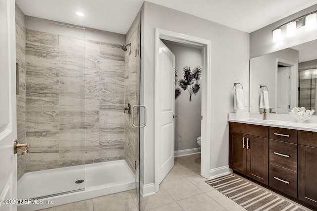 bathroom with tile patterned flooring, an enclosed shower, vanity, and toilet