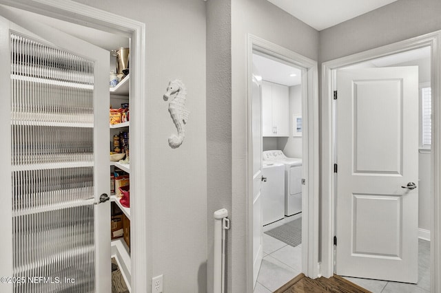 interior space featuring cabinets, independent washer and dryer, and light tile patterned floors