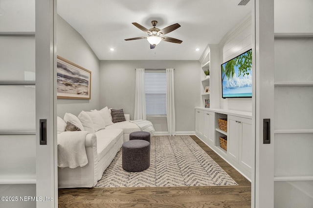 living room with lofted ceiling, built in shelves, ceiling fan, and dark hardwood / wood-style flooring