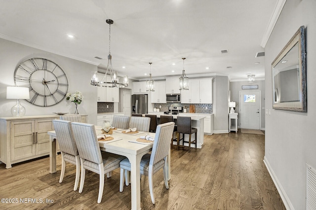 dining space with ornamental molding and hardwood / wood-style floors