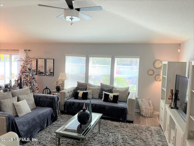 living room featuring a textured ceiling, light hardwood / wood-style flooring, and ceiling fan