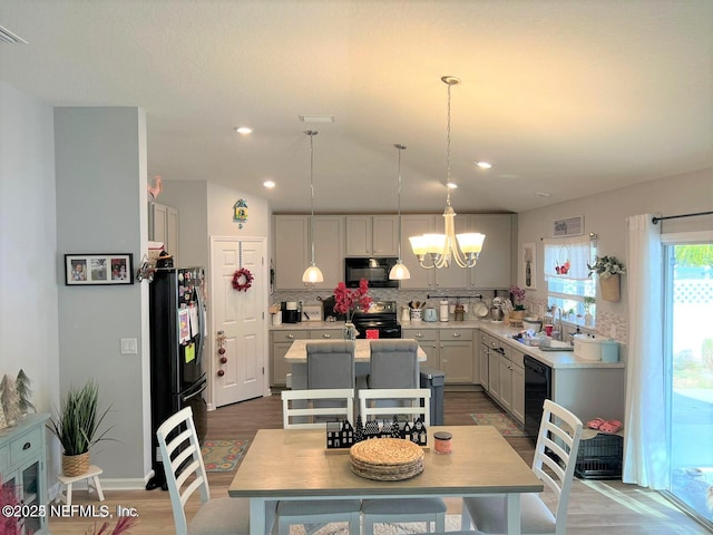 kitchen with gray cabinetry, sink, black appliances, pendant lighting, and hardwood / wood-style flooring