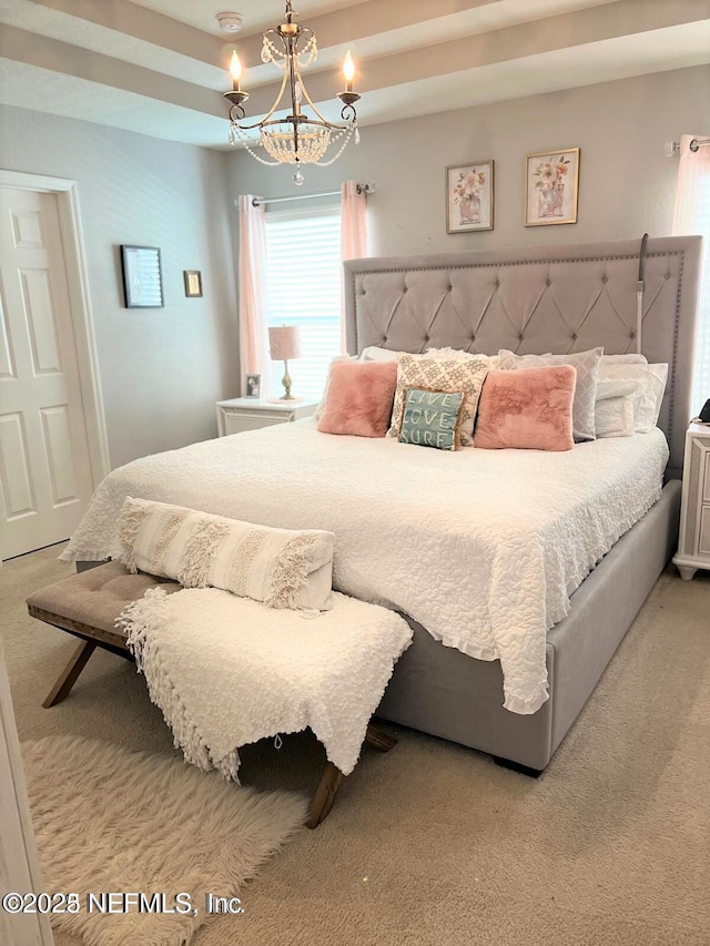 carpeted bedroom featuring a chandelier